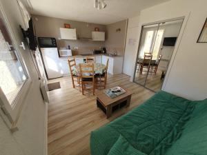 a living room with a couch and a table and a kitchen at Arriu 35 in Bielle