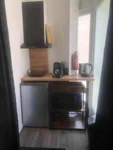 a kitchen with a counter with a microwave and a tv at Élégant Studio avec Sauna Hyper centre in Saint-Dizier +30 photos