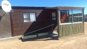 a small building with a door and a window at Megs Accommodation in Kamieskroon