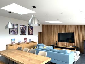 a living room with two blue couches and a table at Le Chai de Castres Gironde in Castres-Gironde