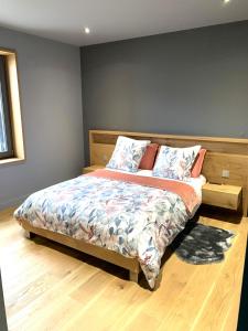 a bedroom with a bed with a wooden headboard at Le Chai de Castres Gironde in Castres-Gironde