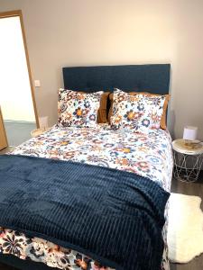 a bedroom with a large bed with a blue headboard at Le Chai de Castres Gironde in Castres-Gironde