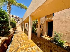 un edificio con una palmera al lado de una acera en Darwins Luxury Mojácar, en Mojácar