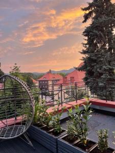a rattan chair sitting on top of a balcony at Szmaragdowa Sowa in Wałbrzych