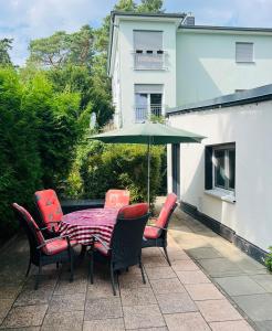 a table and chairs with an umbrella on a patio at Ferienhaus Green Garden Berlin - Welcome to Berlin in Berlin