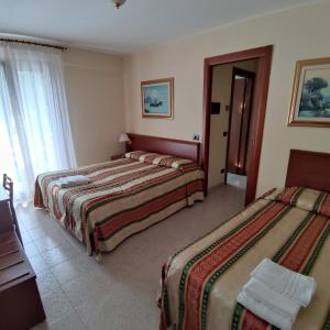 una camera d'albergo con due letti e una finestra di Ponte Nuovo ad Altissimo Altre 15 foto