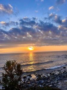 un tramonto sull'oceano con il sole che tramonta di La casa sul blu Acciaroli Casa Vacanze ad Acciaroli Altre 5 foto