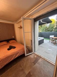 a bedroom with a bed and a sliding glass door at La suite secrète et son spa abrité in Nancy +29 photos