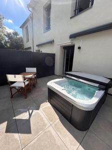 a hot tub on a patio next to a building at La suite secrète et son spa abrité in Nancy