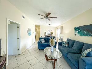a living room with a blue couch and a table at Spacious Shorewalk 2B-2B Condo near Anna Maria Island, Beaches & IMG Academy in Bradenton