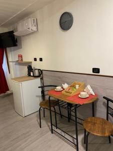a table and chairs in a kitchen with a clock on the wall at Palazzo Carignano in Chioggia +8 photos