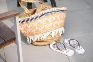 a pair of flip flops and a basket and a pair of shoes at Casita Ouddorp aan Zee in Ouddorp