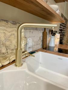 a kitchen sink with a gold faucet at La Suite Drômoise 1809 in Saint-Paul-lès-Romans +48 photos
