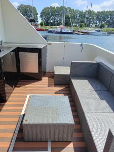 a deck on a boat with couches and a table at MOONLIGHT HOUSEBOAT in Świnoujście