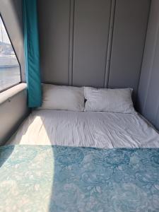 a bed in a small room with a window at MOONLIGHT HOUSEBOAT in Świnoujście