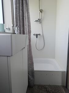 a white bathroom with a shower and a sink at MOONLIGHT HOUSEBOAT in Świnoujście
