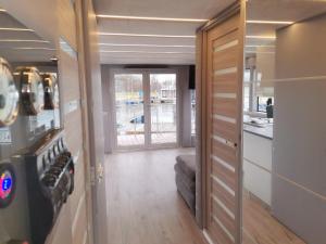 a hallway with a door leading to a room with a kitchen at MOONLIGHT HOUSEBOAT in Świnoujście +7 photos