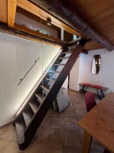 a staircase in a room with a table and chairs at Rustico Efrina, neu renoviert in Frasco