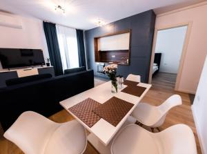 a living room with a white table and white chairs at Modern and Central Apartment in Timişoara