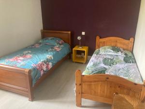 a small bedroom with two beds and a night stand at La Maison du soleil L Aulhere 3 étoiles ,Maison familiale 6-7 personnes, Grand Jacuzzi 6 p , Repas traiteur et massages bien-être en option in Oloron-Sainte-Marie +73 photos