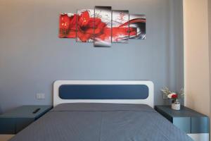 キアーヴァリにある243b - Appartamento Mignon - Sara Home Chiavari, 200metri dal Mareの赤い葉の絵が描かれたベッドのある寝室