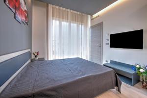 キアーヴァリにある243b - Appartamento Mignon - Sara Home Chiavari, 200metri dal Mareの大きなベッドと薄型テレビのある寝室