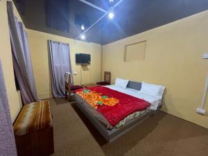 a bedroom with a bed with a red blanket at The Qulsum Homestay in Srinagar