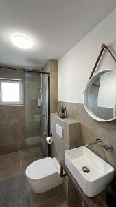 ein Badezimmer mit Toilette, Waschbecken und Dusche in der Unterkunft Casa Estella in Rust + 37 Fotos