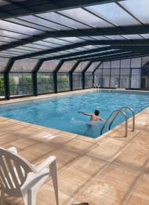 a man in a swimming pool in a building at Arriu 35 in Bielle