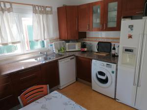 a kitchen with a white refrigerator and a dishwasher at Lagoa House Albufeira in Lagoa de Albufeira