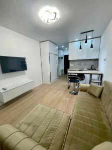a living room with a couch and a table and a kitchen at Seaview studio apartment in Gonio