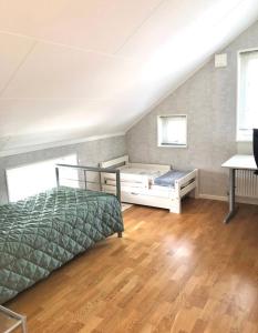 a attic bedroom with two beds and a wooden floor at RosaVillan in Kolmården +39 photos