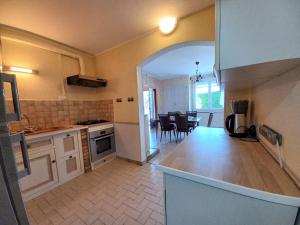 a kitchen with white cabinets and a dining room at Calme et nature proche centre-ville et rivière in Die