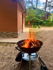 a bbq grill with fire in it in a yard at Villa Capricorn in Tsigov Chark