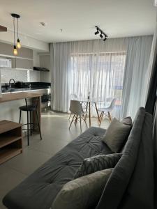 a living room with a couch and a kitchen at Flat Por do Sol in São Lourenço