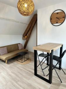 a dining room with a table and a couch at Appartements Pacy-sur-Eure in Pacy-sur-Eure