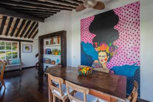 una sala da pranzo con tavolo e un dipinto sul muro di Villa Vermelha Ocean View a Búzios