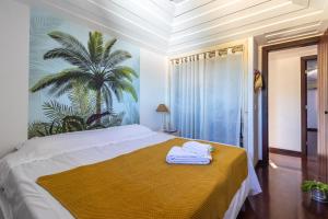 una camera da letto con un grande letto con una coperta gialla di Villa Vermelha Ocean View a Búzios Altre 60 foto