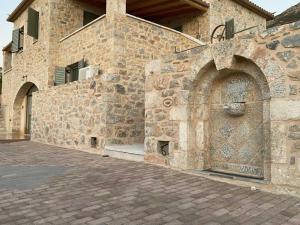 a stone building with a stone wall with an arch at NORI House in Moláoi +3 photos