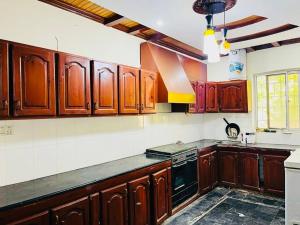 a kitchen with wooden cabinets and a stove top oven at Bhurban Lodges in Murree +6 photos