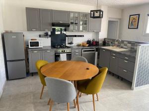 a kitchen with a wooden table and chairs at Spacieux 2 pièces, au calme in Le Tignet