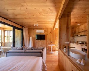 a bedroom with a couch and a sink in a room at Cabañas de Aldán in Aldán