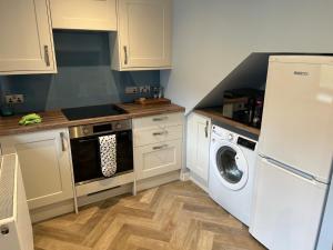 a kitchen with a refrigerator and a washing machine at Oldshorecroft in Sheigra