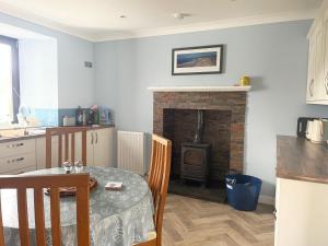 a kitchen with a table and a brick fireplace at Oldshorecroft in Sheigra +14 photos