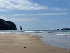a person standing in the water on a beach at Oldshorecroft in Sheigra