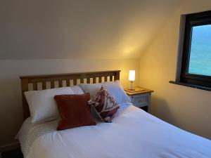a bedroom with a bed with pillows and a window at Oldshorecroft in Sheigra