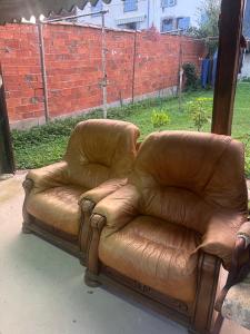 a brown leather couch sitting in a yard at Studio St Florentin in Saint-Florentin