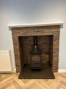 a brick fireplace with a stove in a room at Oldshorecroft in Sheigra