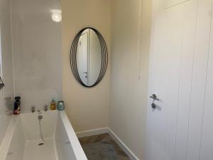 a bathroom with a tub and a mirror on the wall at Oldshorecroft in Sheigra