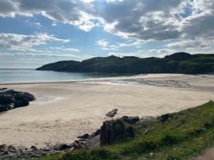 a sandy beach with rocks and the ocean at Oldshorecroft in Sheigra
